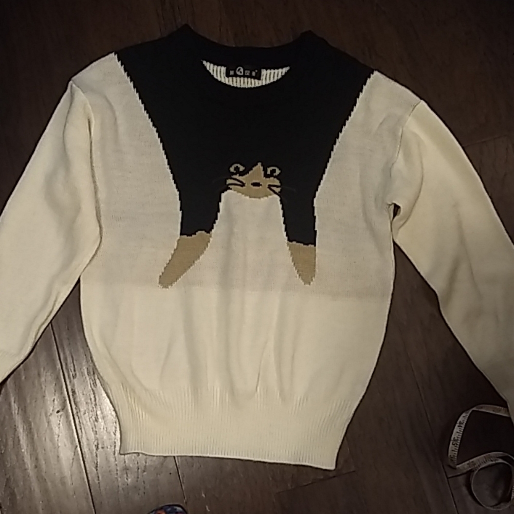 Cat hanging over shoulders sweater